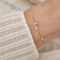 Bracelet doré porté au poignet, pull crème