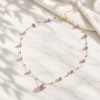 Collier de perles fantaisie lilas sur chaîne dorée