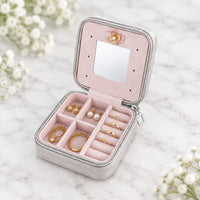 Étui à bijoux de voyage gris ouvert : miroir, cases et rouleaux à bagues